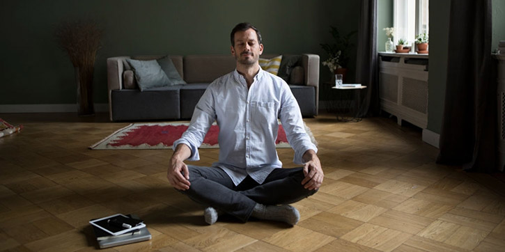 Uomo in meditazione seduto sul pavimento