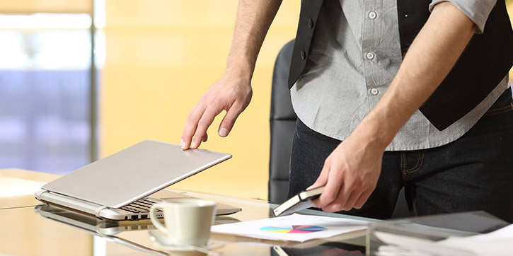 Uomo che chiude laptop per iniziare digital detox