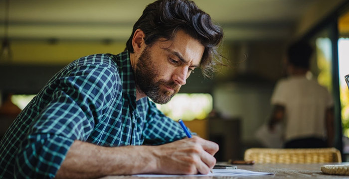 Uomo che scrive il proprio diario ad una scrivania